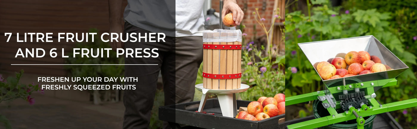 Wooden fruit crusher and stainless steel fruit press, surrounded by fresh apples in a garden setting, ideal for juicing