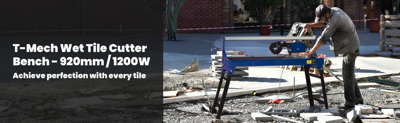 T-Mech wet tile cutter in use, featuring a blue frame, cutting tiles on a construction site with scattered materials and tools