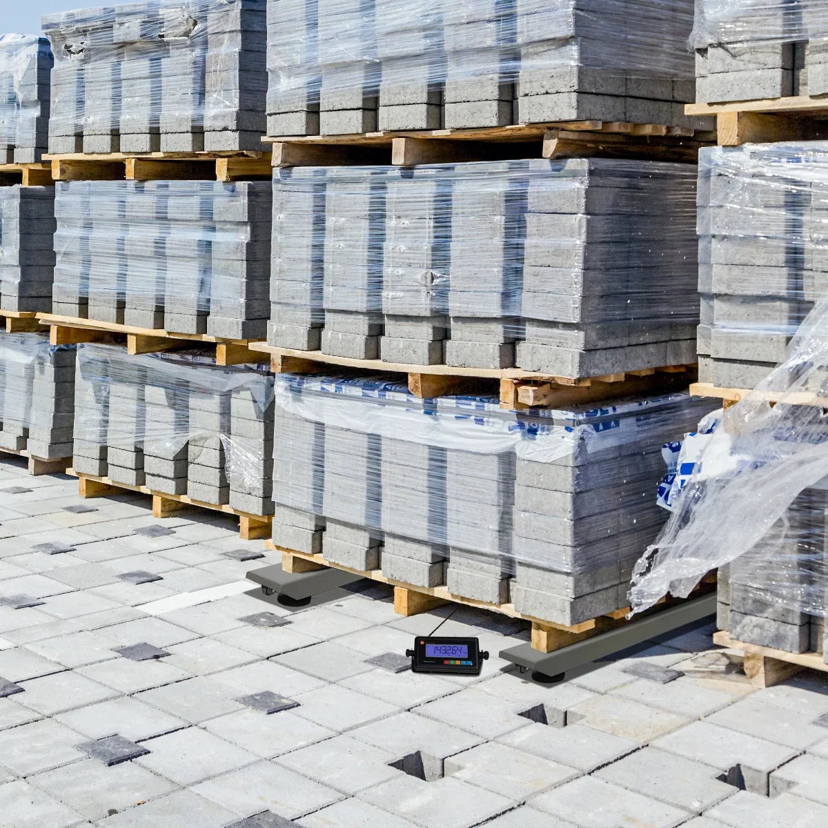 T-Mech Industrial Weighing Beam Scales positioned on a pallet, surrounded by stacked concrete blocks in a construction site setting