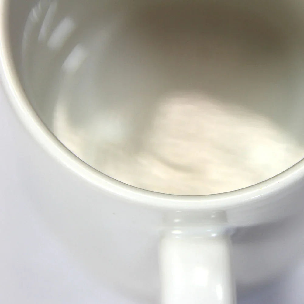 Close-up of a white ceramic 11oz mug showing smooth interior and handle detail.