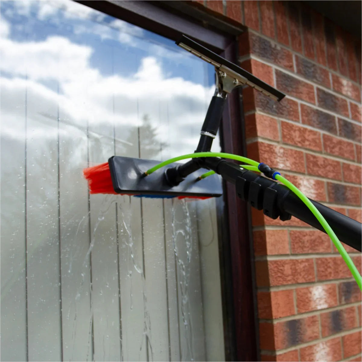 Water fed backpack with 24ft cleaning pole, featuring a squeegee and brush, cleaning a window with streak-free results