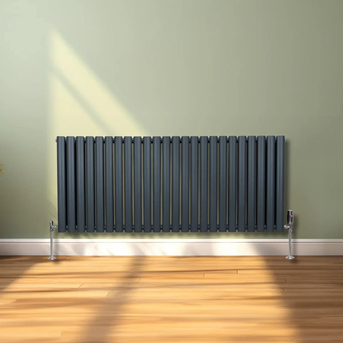 Oval column radiator in anthracite grey, 600mm x 1440mm, featuring sleek vertical bars and chrome valves against a light green wall