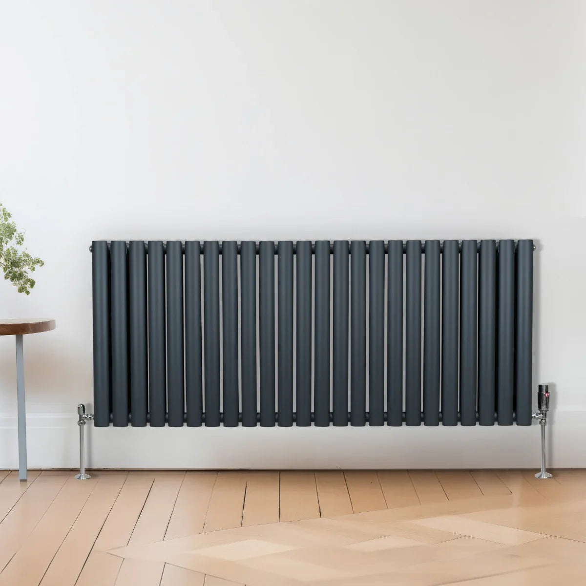 Oval column radiator in anthracite grey, 600mm x 1440mm, featuring vertical slats and sleek metal valves, mounted on a wooden floor