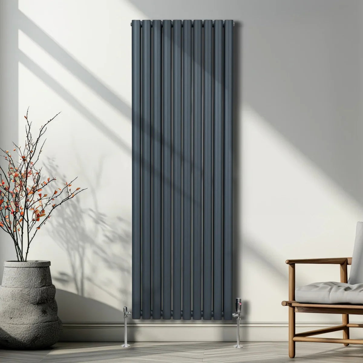 Oval column radiator in anthracite grey, 1800mm x 600mm, featuring vertical slats and sleek chrome valves, set against a modern interior