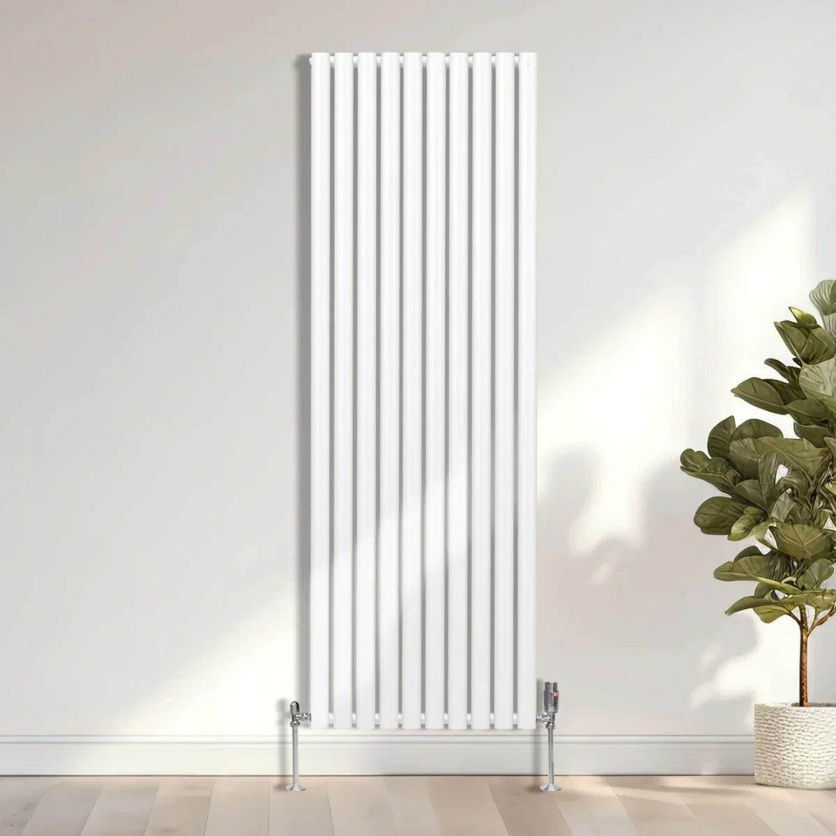 Sleek white oval column radiator with vertical bars, standing 1800mm tall and 600mm wide, complemented by chrome valves and a modern setting