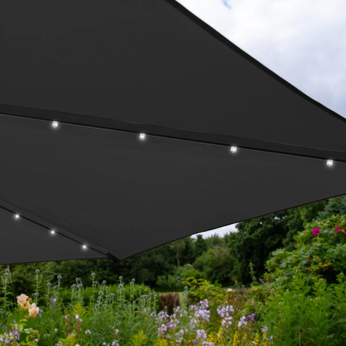Grey 3m LED cantilever parasol with integrated lights, showcasing a sleek design against a vibrant garden backdrop