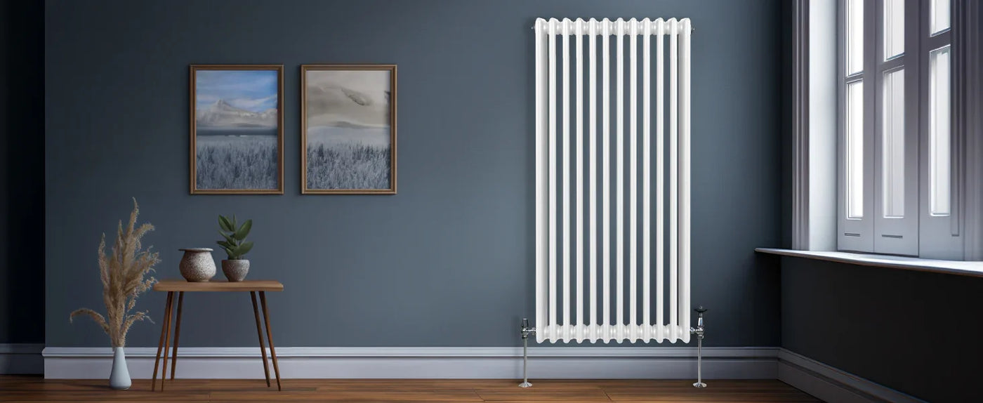 Modern white vertical radiator against a dark blue wall, complemented by framed landscape art, a wooden table, and decorative plants
