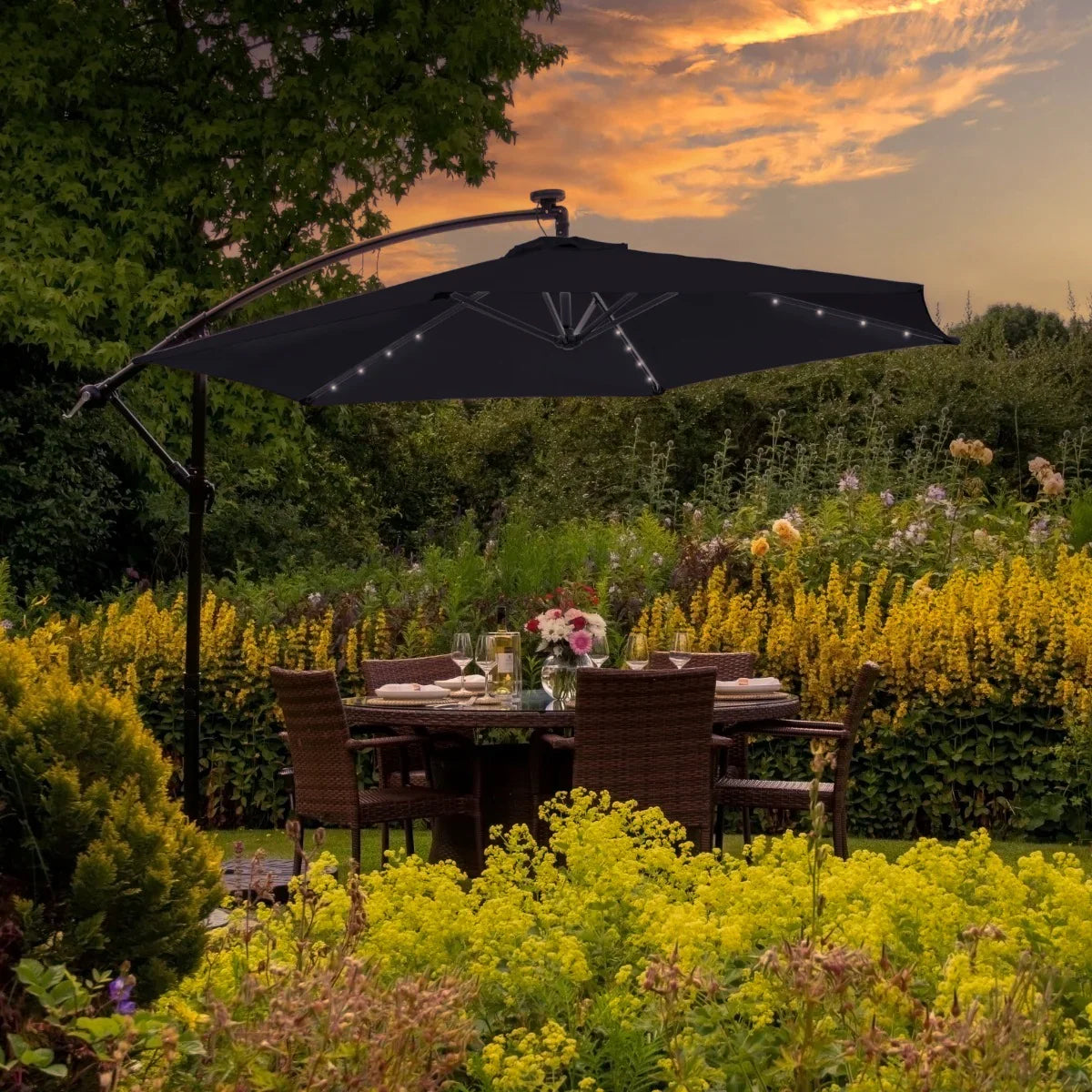 Black 3m LED cantilever parasol with fan base, featuring a sleek design, illuminated edges, and set against a vibrant garden backdrop