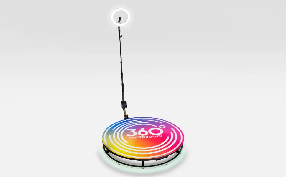 Colorful 360° photobooth with a circular platform, adjustable microphone stand, and vibrant gradient design for engaging photo experiences