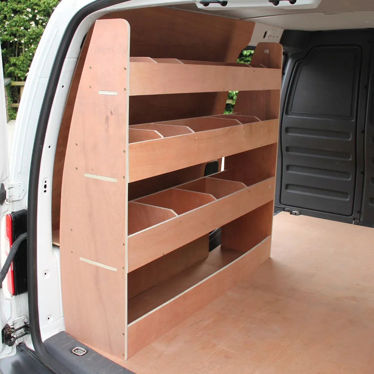 Black van lining with a wooden shelving unit, featuring multiple compartments, installed in a VW Caddy interior