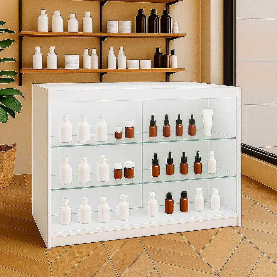 LED retail shop counter K1200 in white, featuring glass shelves displaying various bottles and jars in brown and white, set in a modern interior