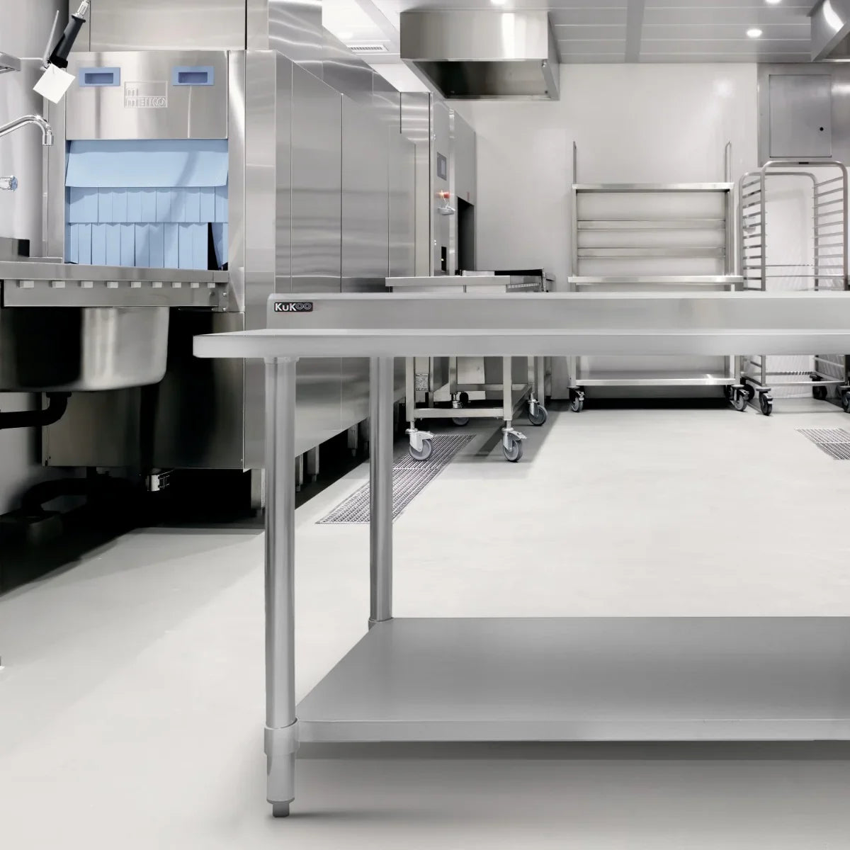 Commercial stainless steel catering table, 4FT wide, featuring a smooth surface, sturdy legs, and a lower shelf for storage in a modern kitchen setting