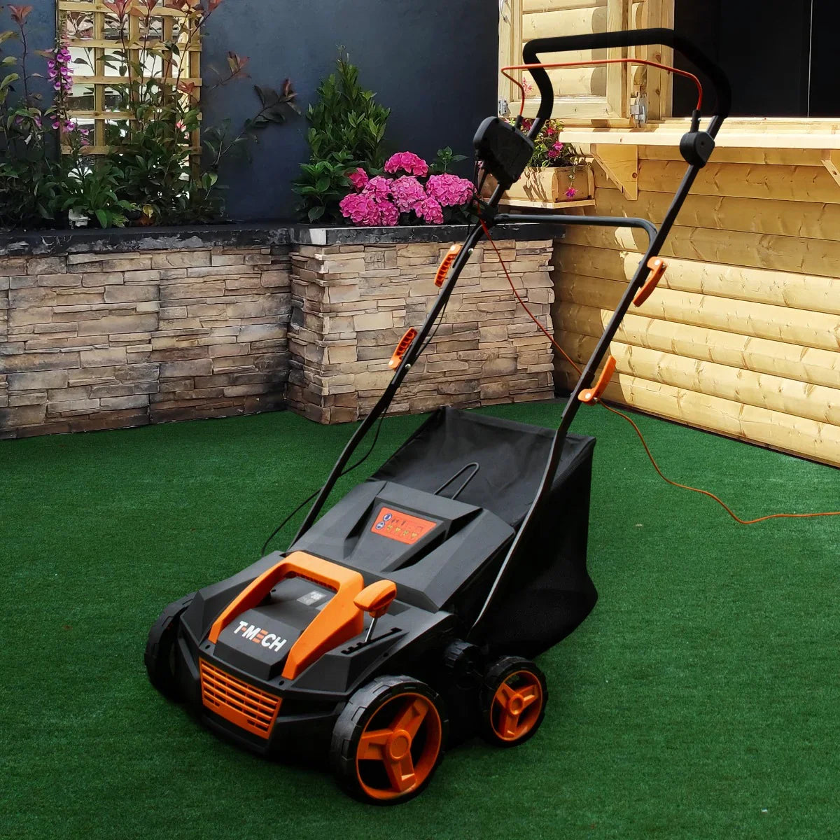 T-Mech Artificial Grass Vacuum in black and orange, featuring a sturdy design, large wheels, and a spacious collection bag, ideal for lawn maintenance