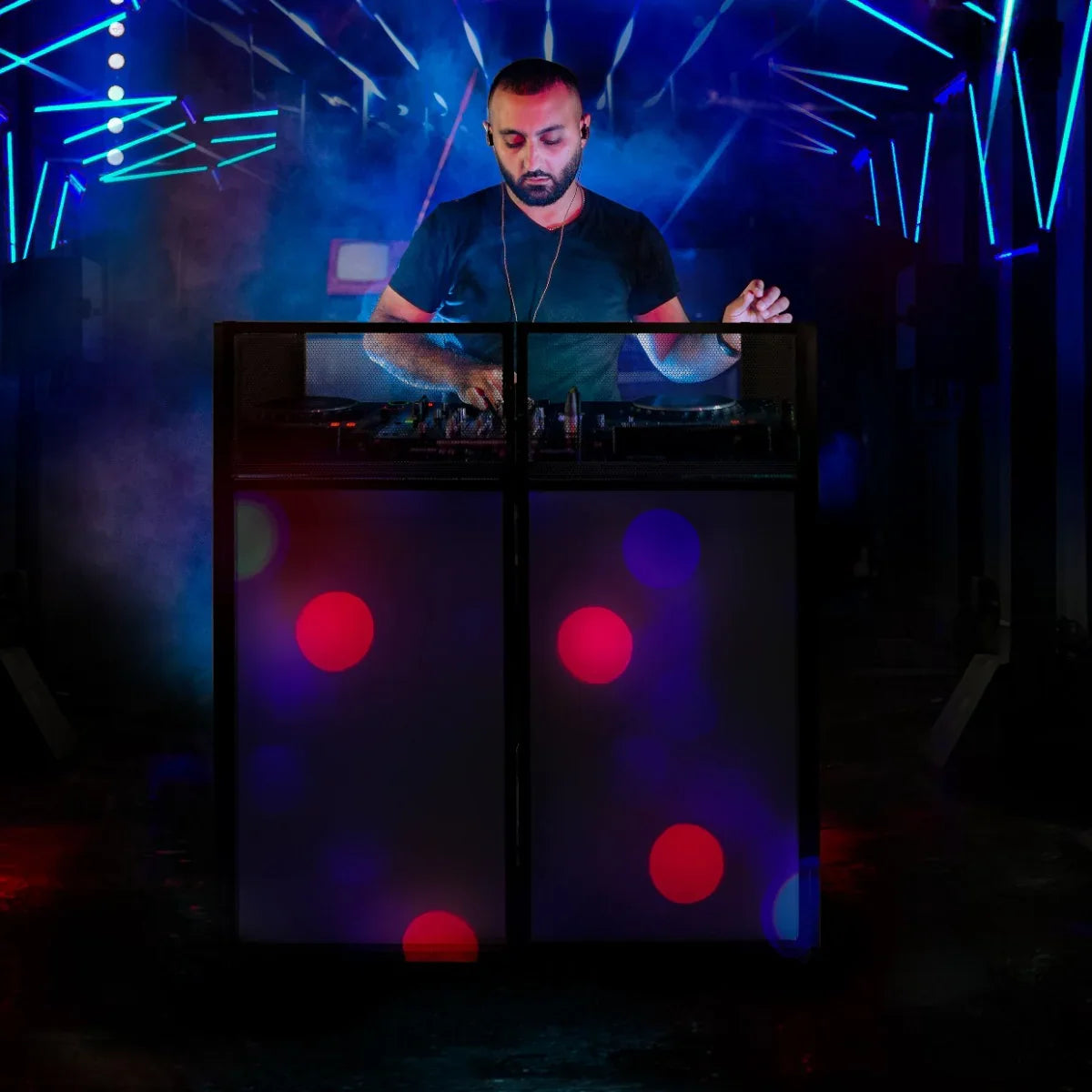 DJ Disco Booth featuring vibrant blue and red lights, a sleek black design, and a DJ mixing music in a lively atmosphere