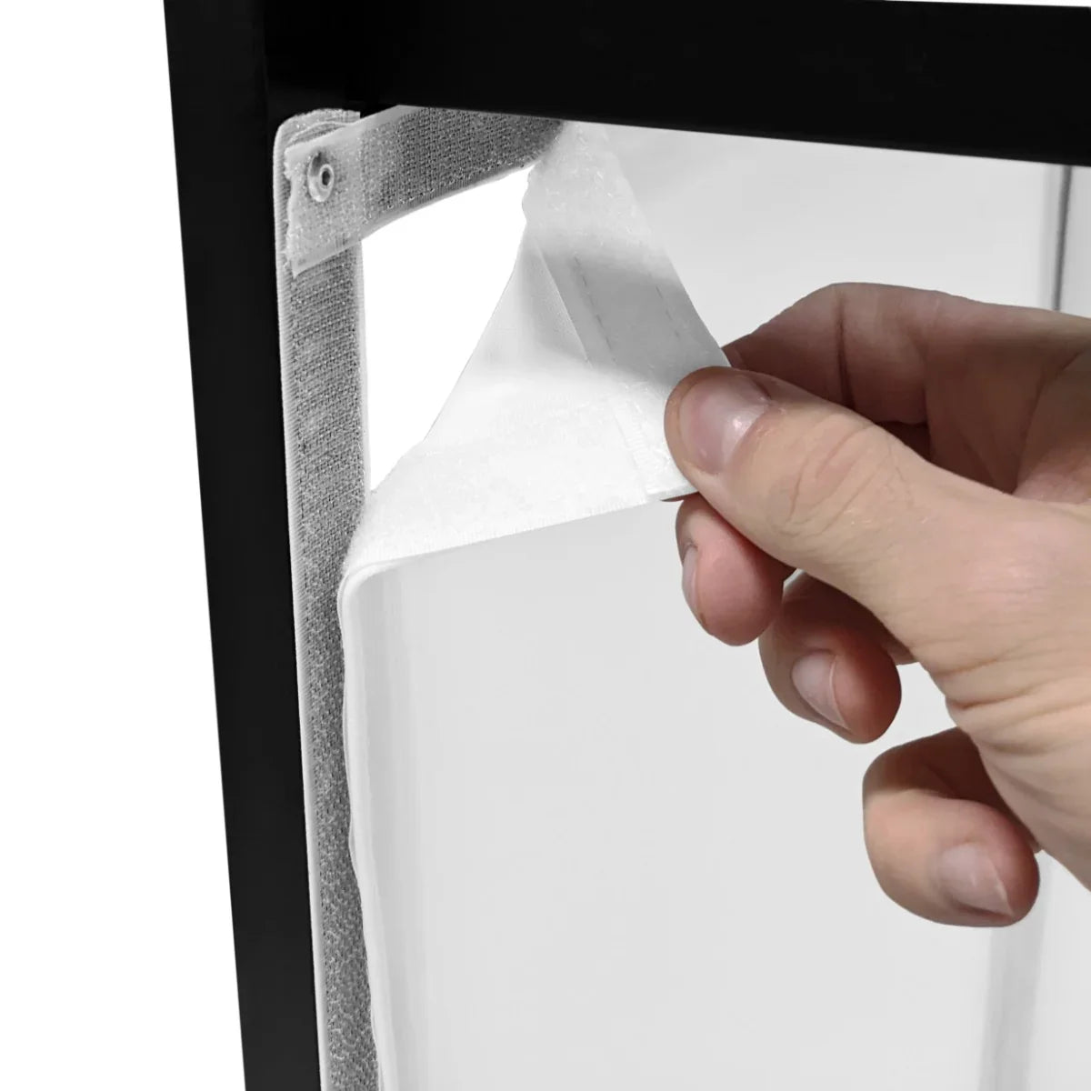 Hand adjusting the fabric panel of a DJ Disco Booth, showcasing its sleek black frame and transparent design for easy setup