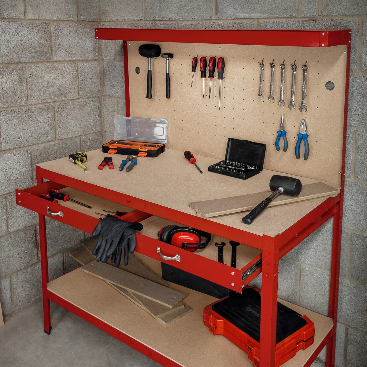 Red workbench featuring a pegboard for tools, two drawers, and an overhead light, set against a concrete wall backdrop
