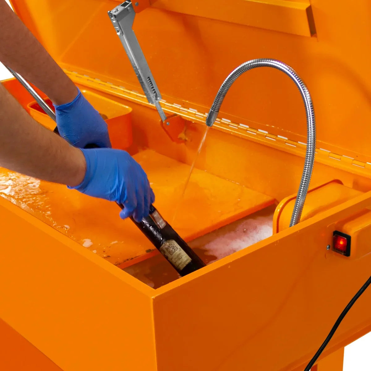 40-gallon parts washer with bright orange finish, featuring a user cleaning a part with gloves, water flowing from the nozzle