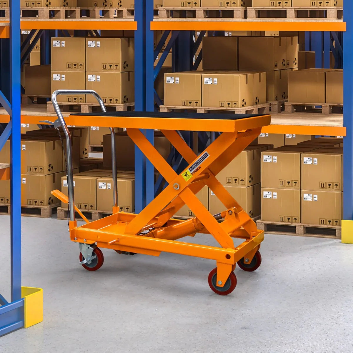 Hydraulic table lift in bright orange, featuring a sturdy metal frame, wheels for mobility, and a scissor lift design, set against a backdrop of stacked cardboard boxes