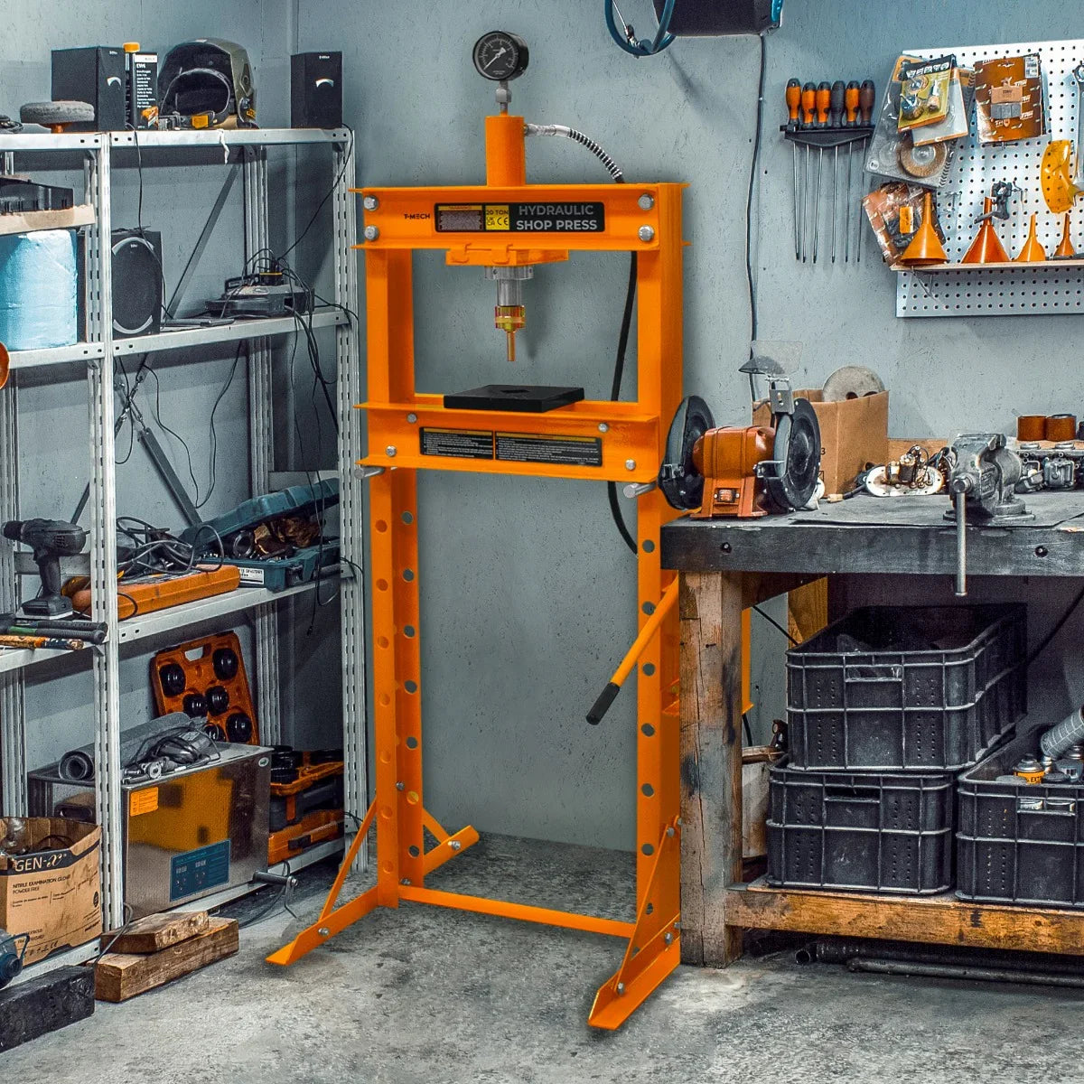 Bright orange hydraulic shop press with gauge, featuring a sturdy frame and adjustable pressure settings, set in a workshop environment