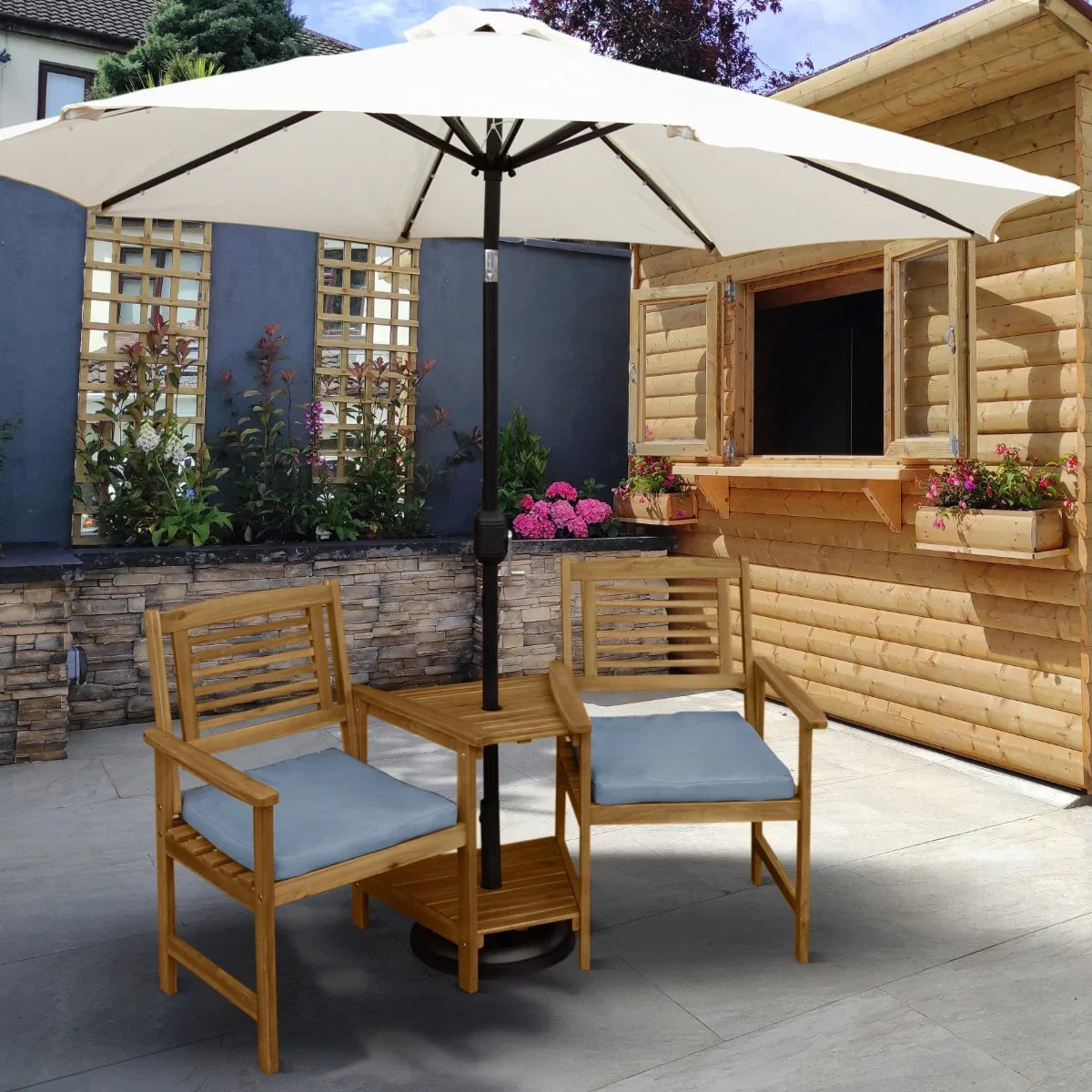 Bamboo companion seat with blue cushions, featuring a central table and a large umbrella, set in a garden patio area