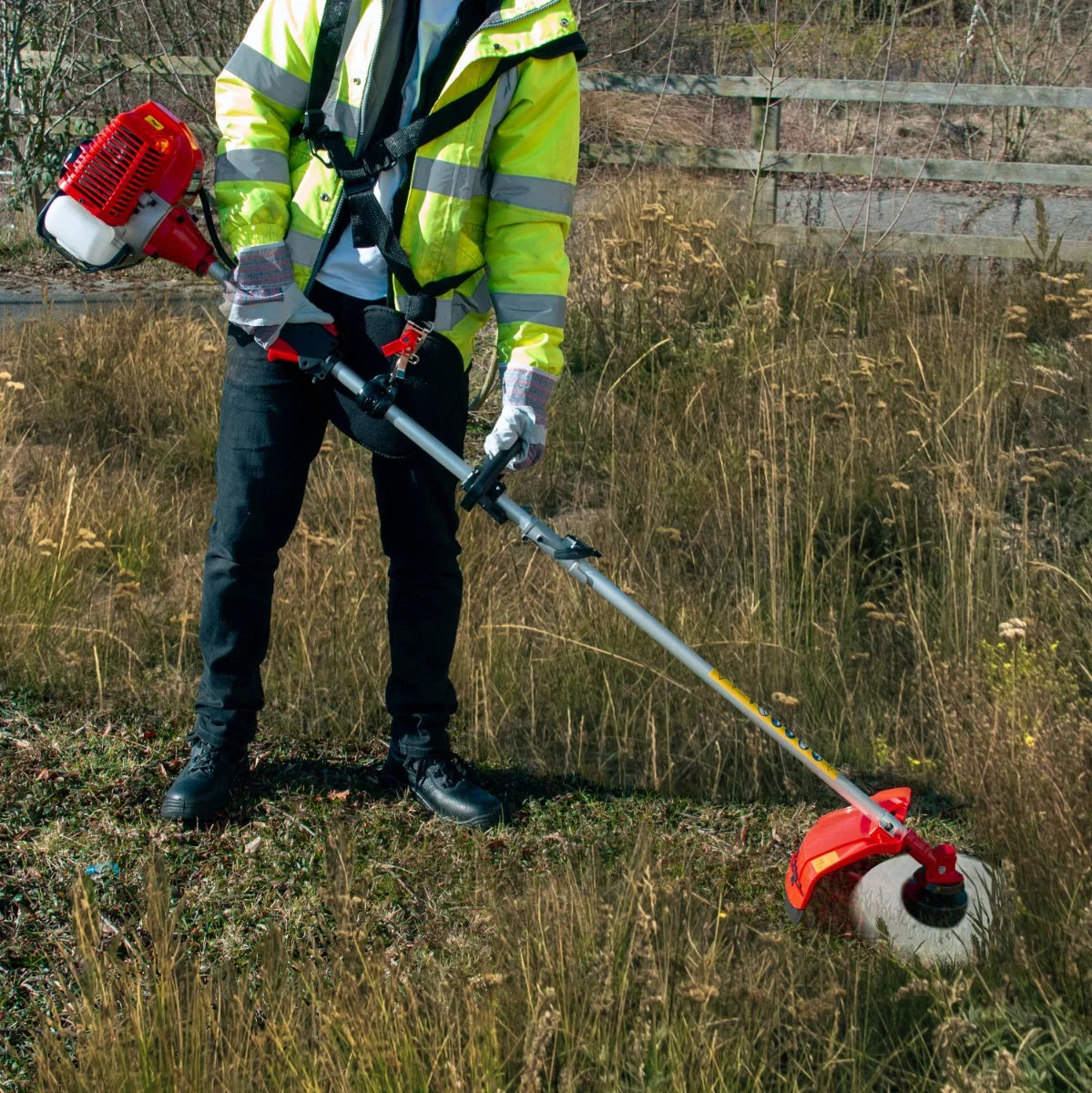 T-Mech 5 in 1 52cc petrol garden cutter multi-tool with red and silver design, cutting through tall grass in a field
