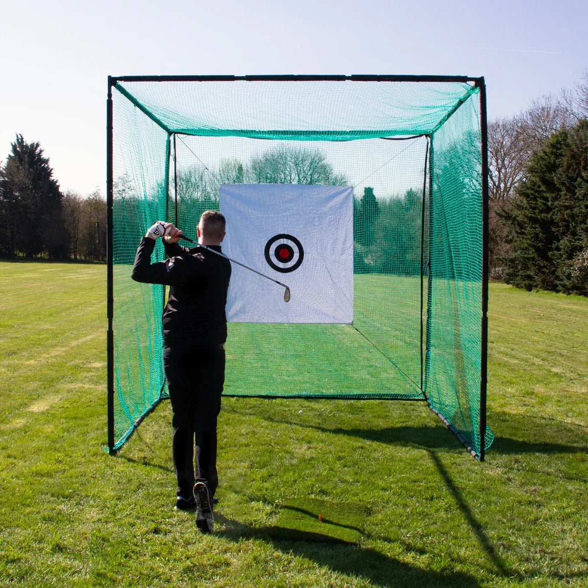 Golf practice cage with green netting and target, set on a grassy field, designed for improving swing accuracy and technique