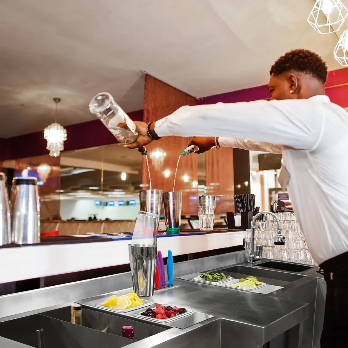 Compact Twin Cocktail Bar Station with stainless steel finish, featuring fresh ingredients, cocktail tools, and a bartender mixing drinks