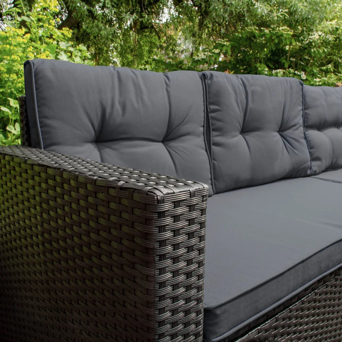 Black rattan corner set featuring thick, plush cushions and a woven texture, ideal for outdoor relaxation and comfort
