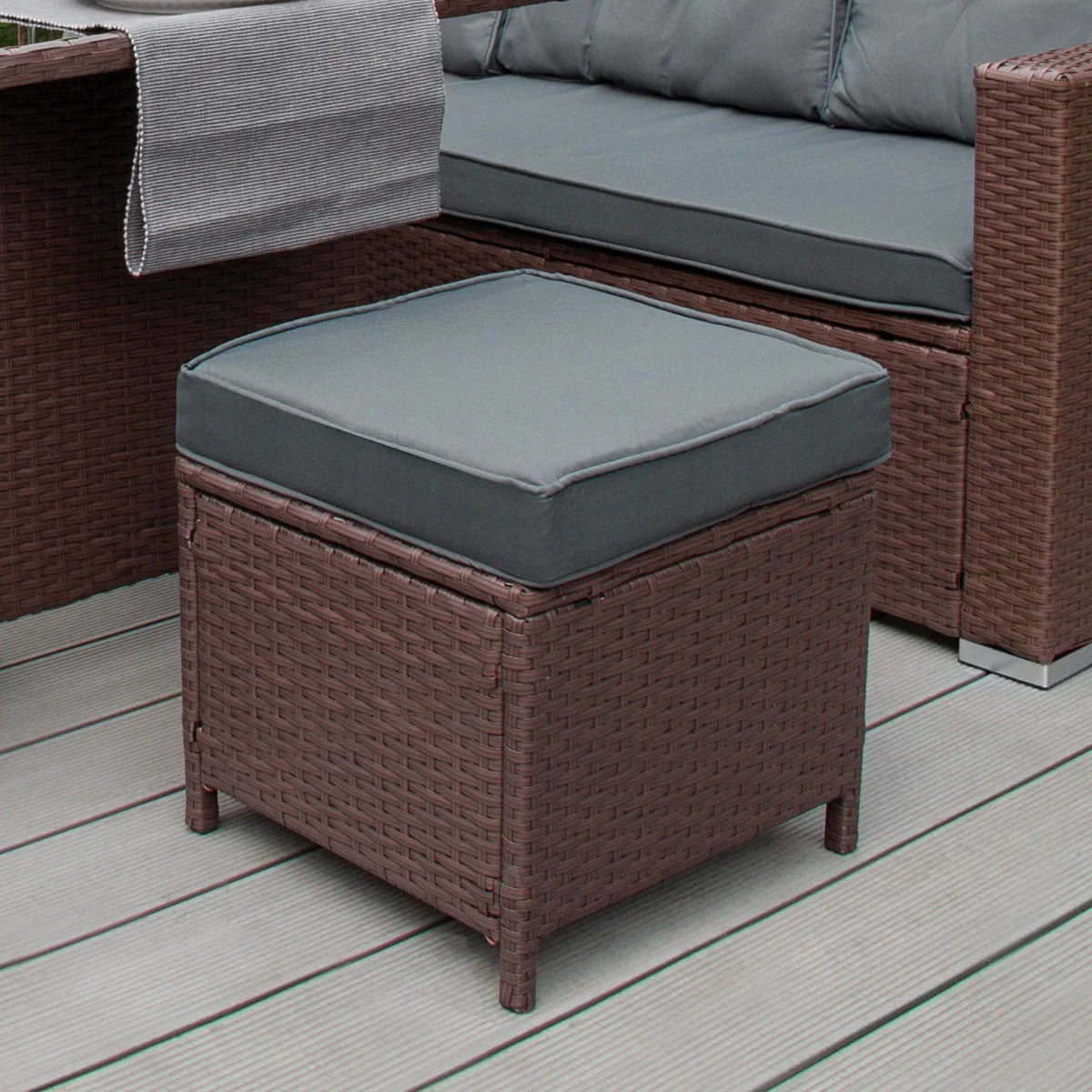 Brown rattan corner set featuring a plush gray cushion on a square ottoman, ideal for outdoor relaxation and stylish seating
