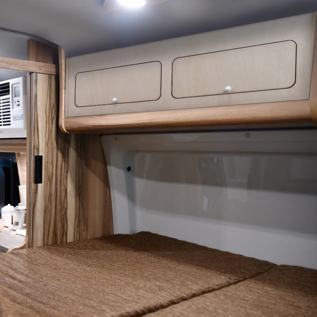 Overhead camper cabinet in light wood finish with two drawers, designed for efficient storage in compact spaces, ideal for camping