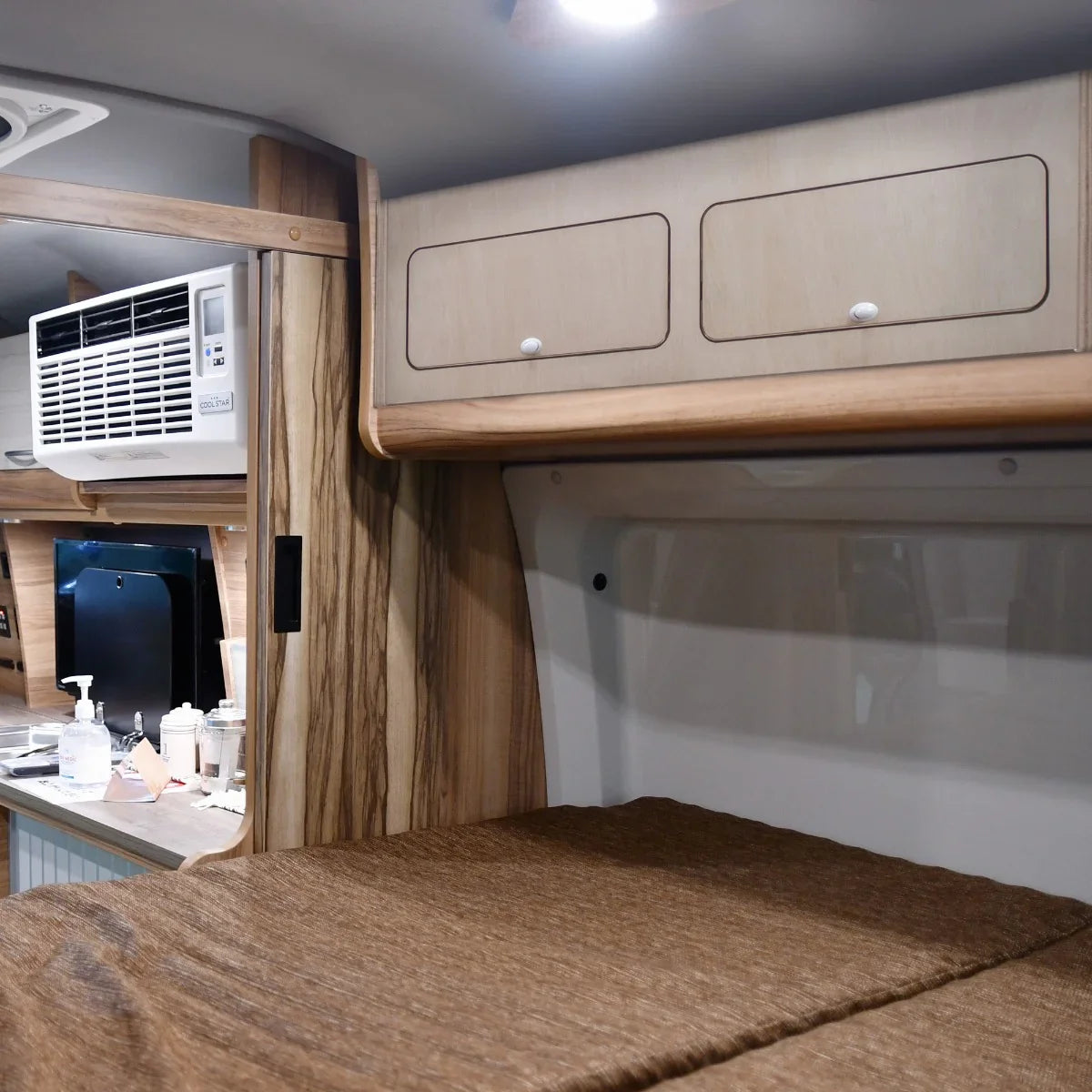 Overhead camper cabinet in light wood finish with two drawers, designed for efficient storage in compact spaces, ideal for camping