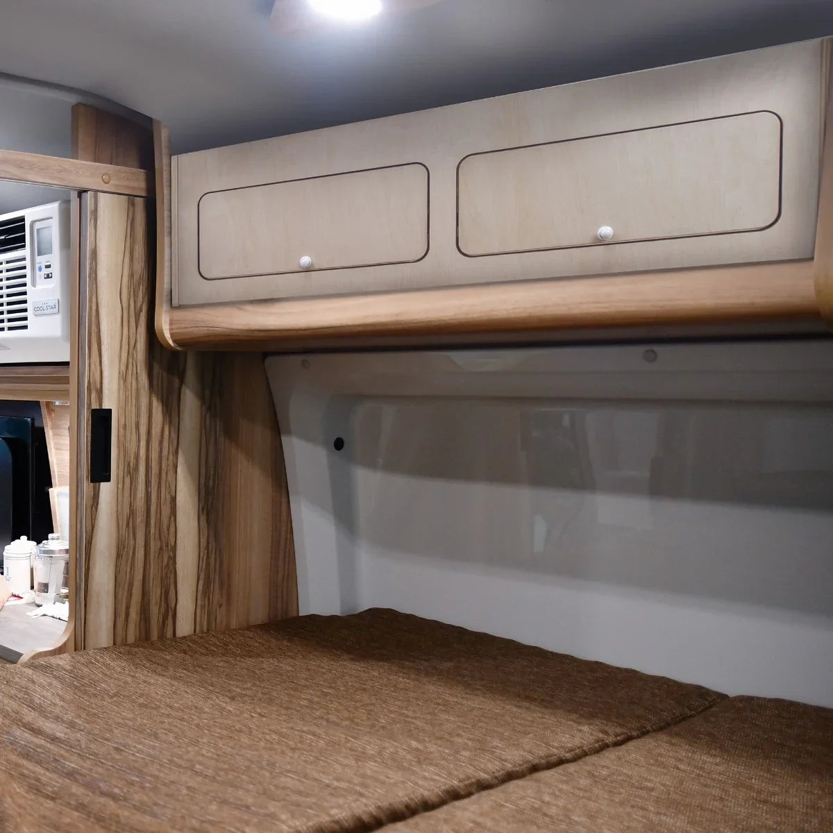 Overhead camper cabinet in light wood with two drawers, featuring a smooth finish and sleek design, ideal for compact storage