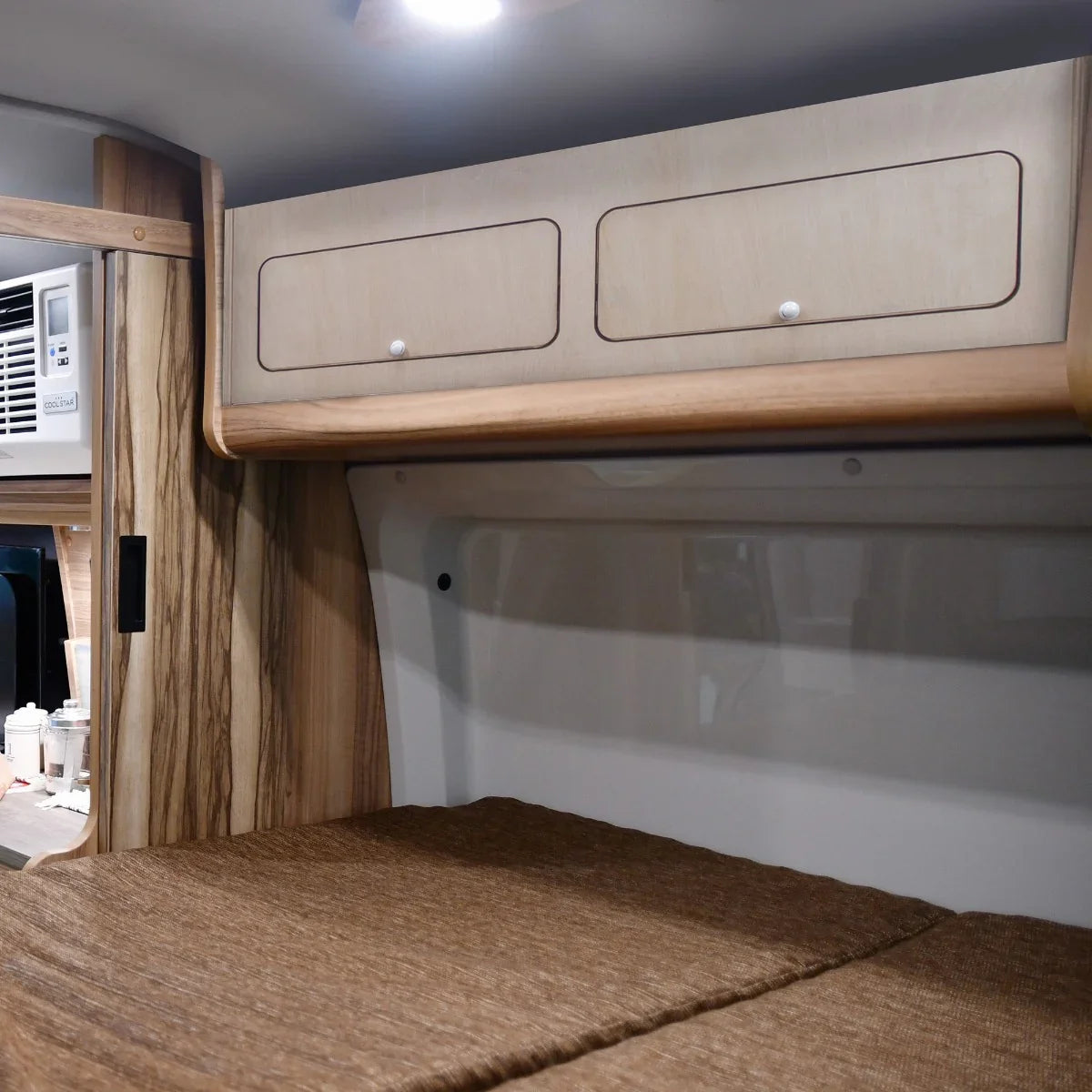 Overhead camper cabinet in light wood finish, featuring two spacious drawers and a sleek design, ideal for efficient storage in small spaces