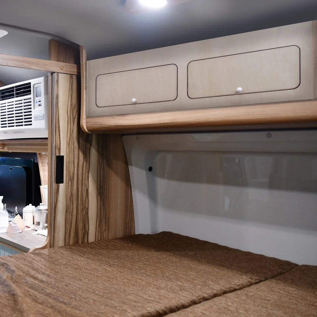 Overhead camper cabinet in light wood with two drawers, featuring a sleek design and smooth finish, ideal for compact storage