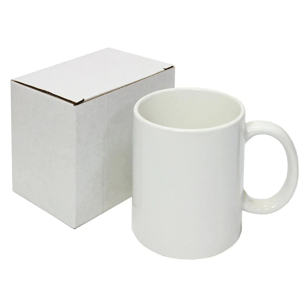 White ceramic mug with large handle beside plain white cardboard box on white background.