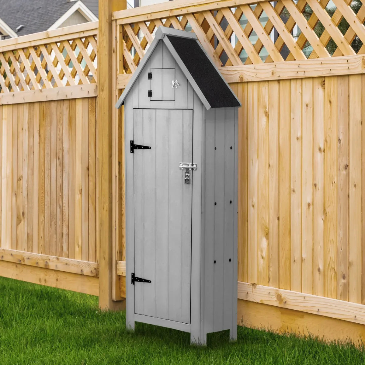 Light grey wooden garden shed with a sloped roof, black shingles, and a lockable door, set against a wooden fence and green grass