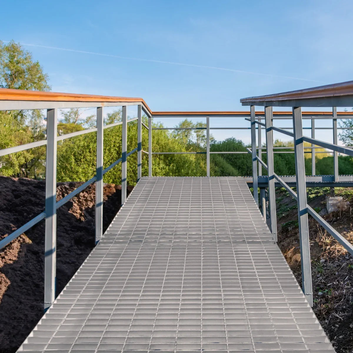 Galvanised grating walkway measuring 1200mm x 1000mm, featuring a sturdy metal frame and textured surface, surrounded by greenery