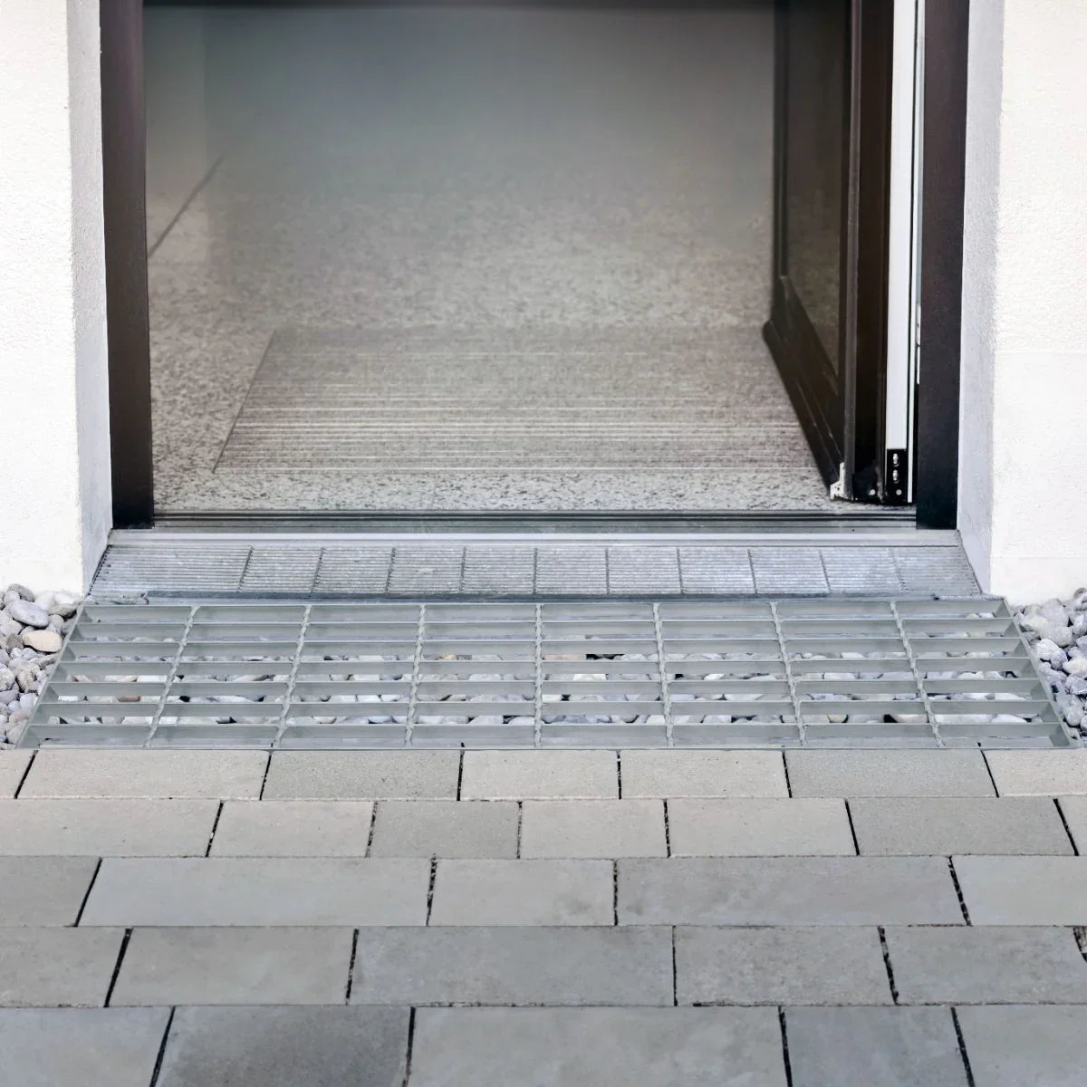 Galvanised grating measuring 800mm x 270mm, featuring a durable metal design with a sleek, silver finish, placed at a doorway