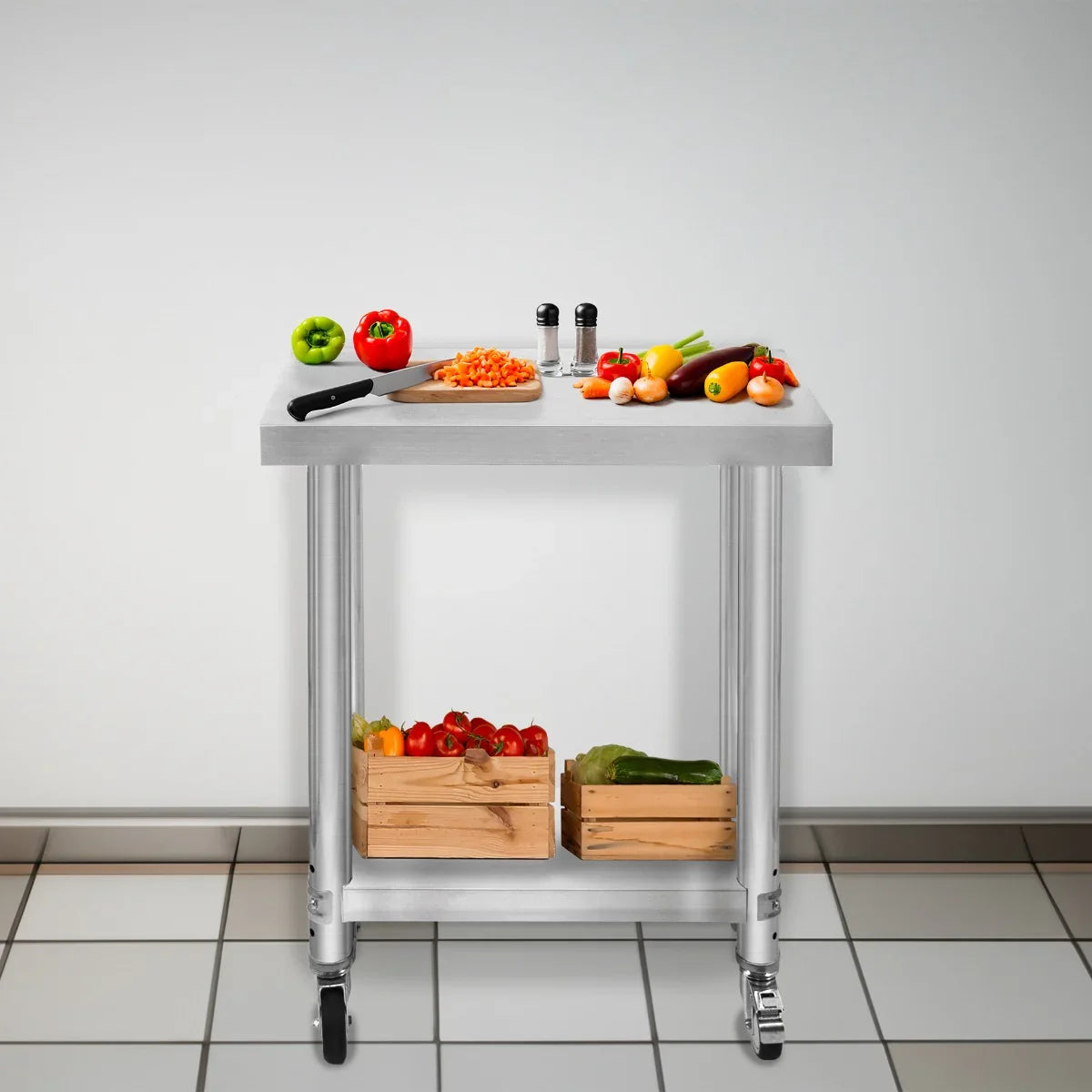 KuKoo Work Table in stainless steel with a smooth surface, featuring fresh vegetables, a cutting board, and wooden crates on wheels
