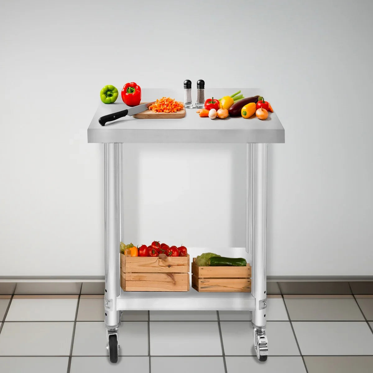 Stainless steel KuKoo work table with a smooth surface, rolling wheels, and fresh vegetables on top and in wooden crates below