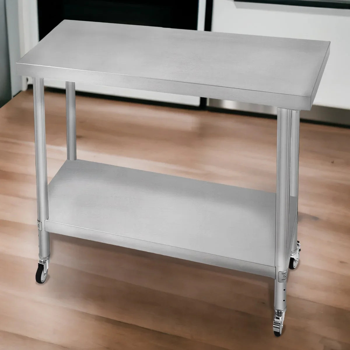 Stainless steel KuKoo work table with a sleek surface, sturdy legs, and a lower shelf, ideal for kitchens or workshops