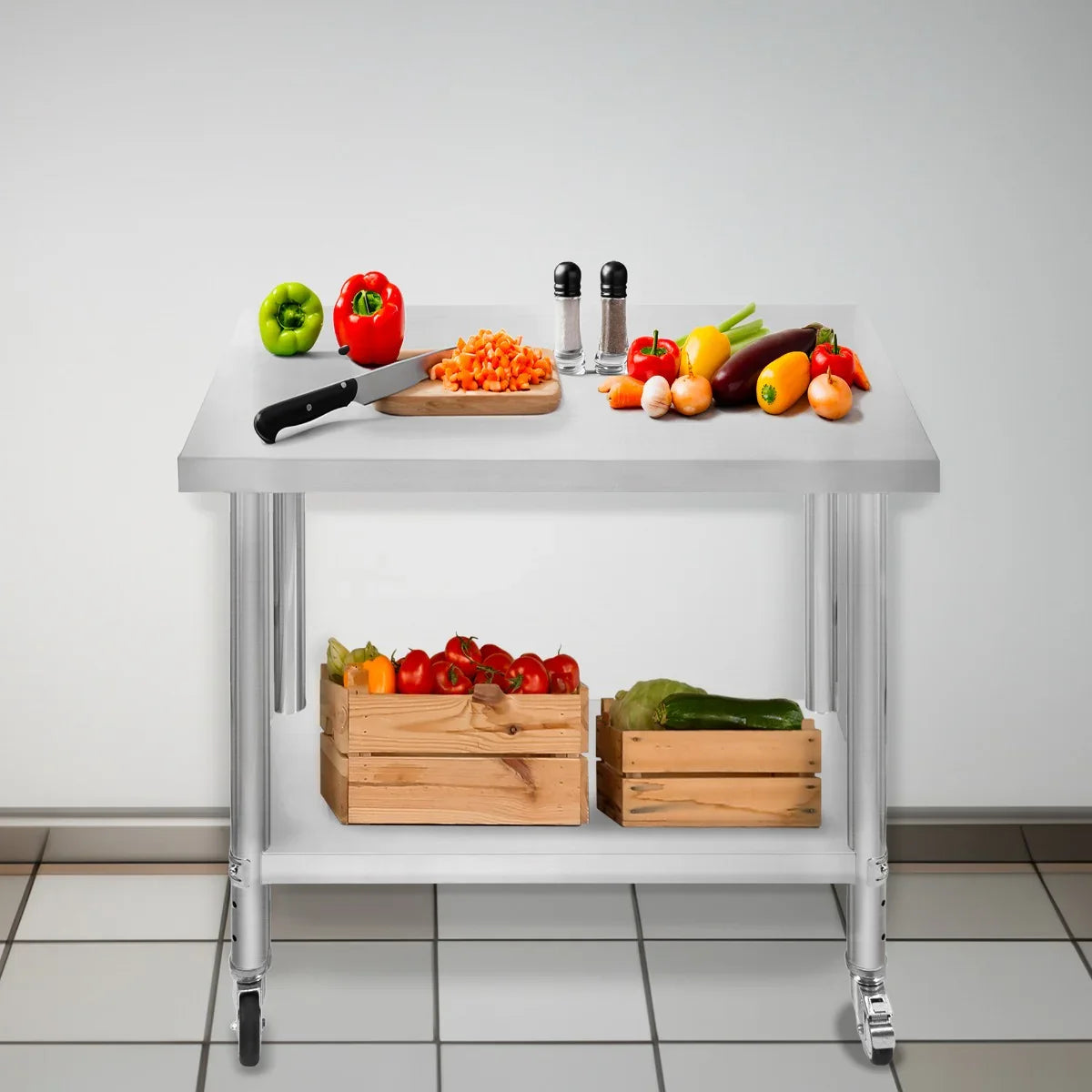 Stainless steel KuKoo work table with a cutting board, knife, and fresh vegetables on top, featuring wooden crates below