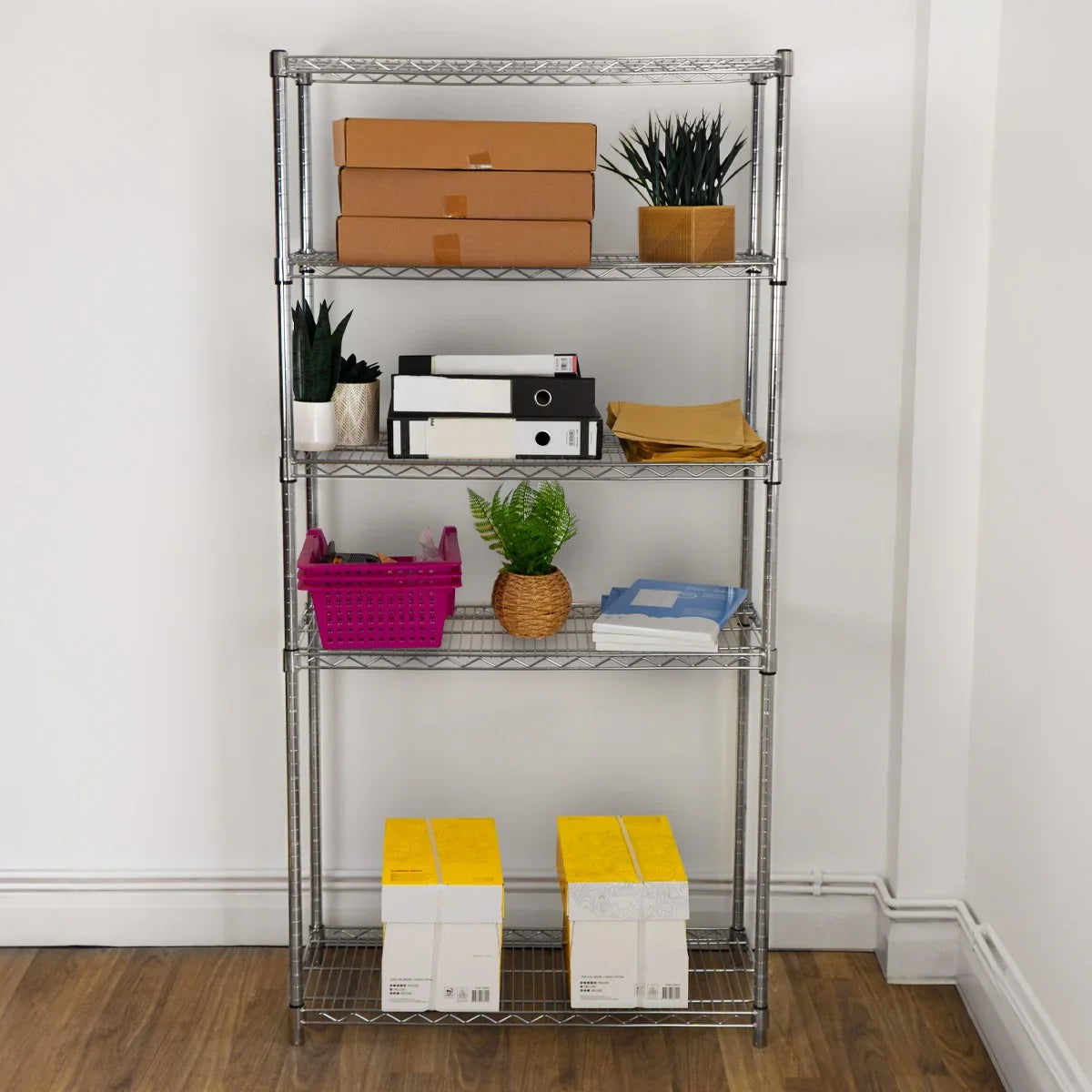 KuKoo Wire Racking unit in silver, featuring five shelves with various storage boxes, plants, and a vibrant pink basket on a wooden floor