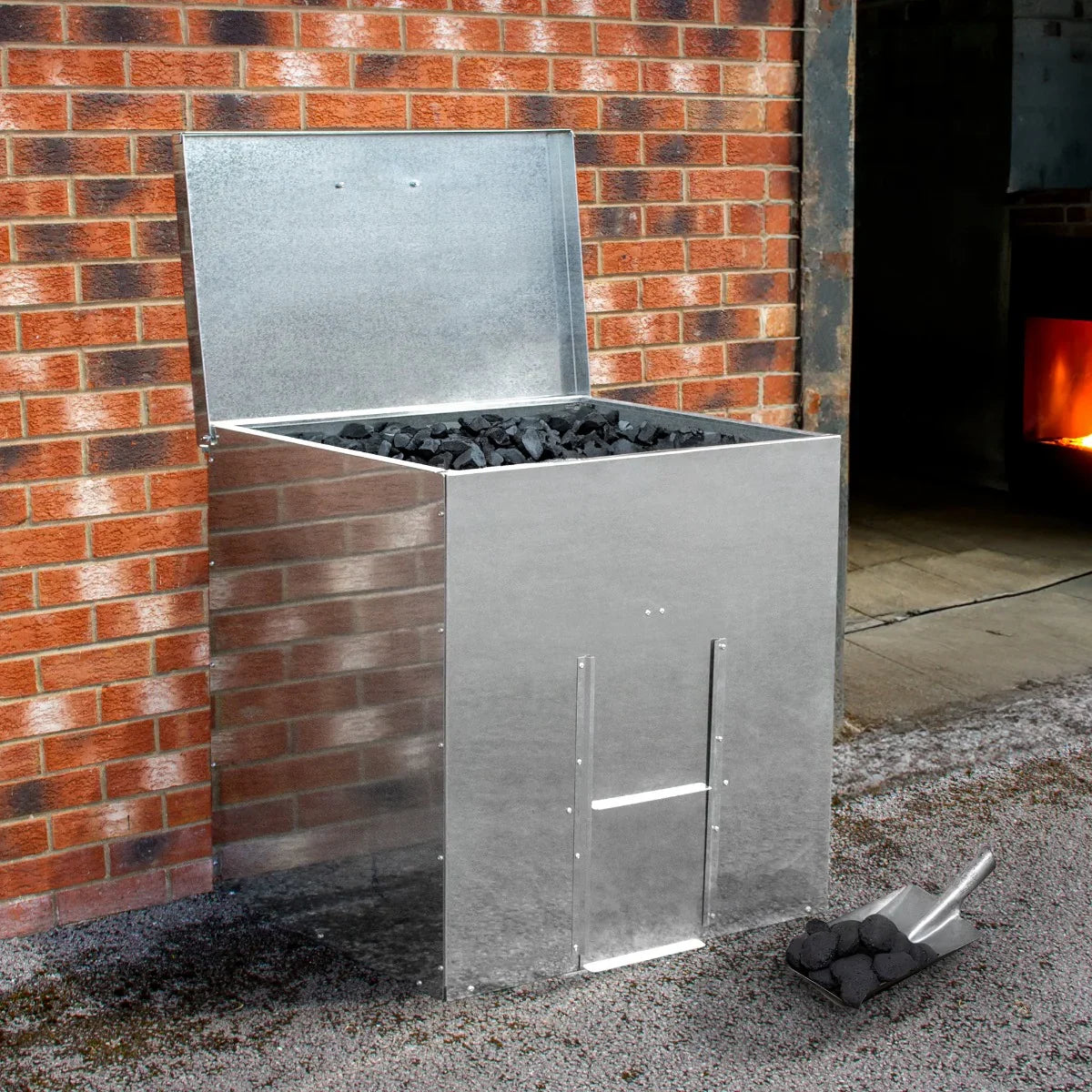 Galvanised coal bunker with a shiny silver finish, holding 350kg of coal, set against a brick wall and gravel floor