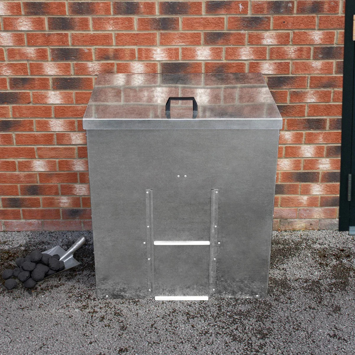 Galvanised coal bunker with a sturdy metal finish, featuring a handle, positioned against a brick wall, ideal for 350kg storage