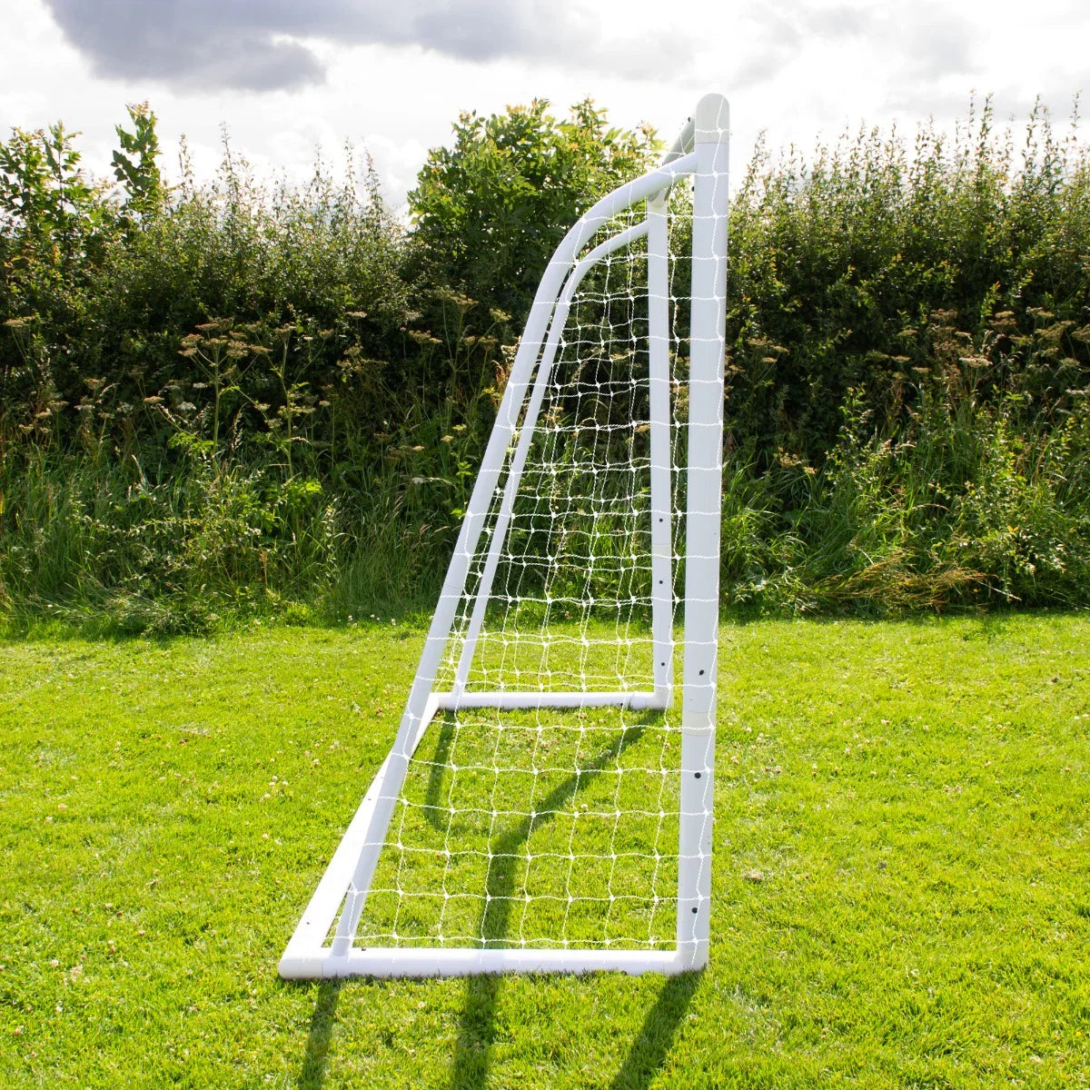 8 x 6ft white football goal with netting, angled view showcasing sturdy frame and grass background, ideal for outdoor play