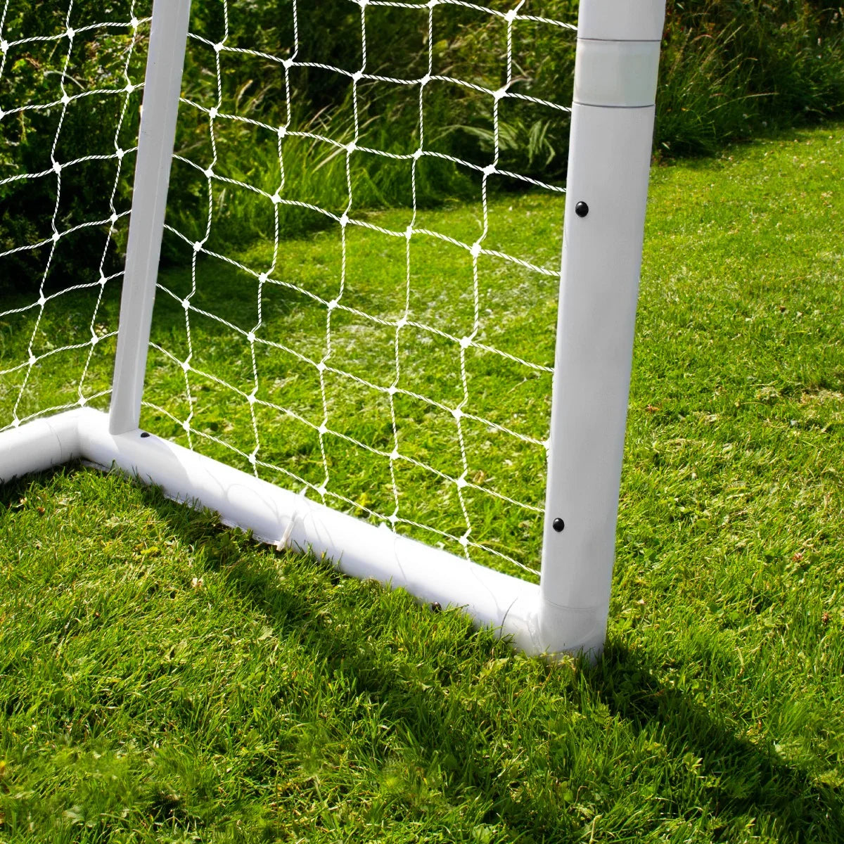 12 x 6ft football goal with white PVC frame, netting, and grass background, showcasing sturdy construction and bright colors