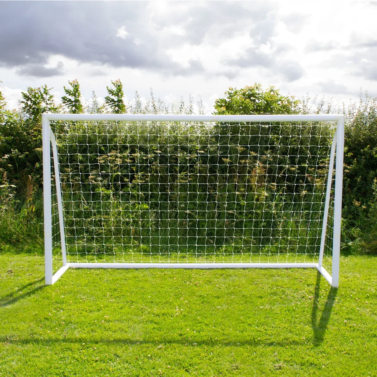 12 x 6ft football goal with white frame and netting, set on green grass under a cloudy sky, ideal for outdoor play