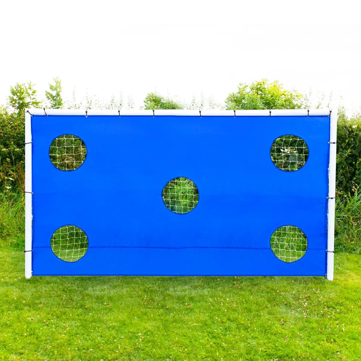 Blue target sheet for a 12 x 6ft football goal, featuring five circular cutouts, set against a grassy background
