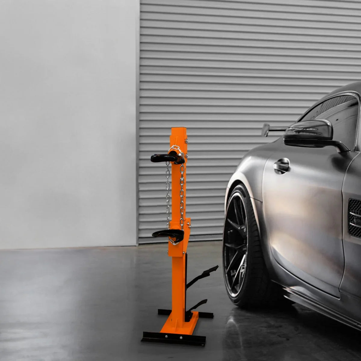 Hydraulic Coil Spring Strut 3T in bright orange, featuring sturdy metal construction, adjustable height, and a sleek design beside a car